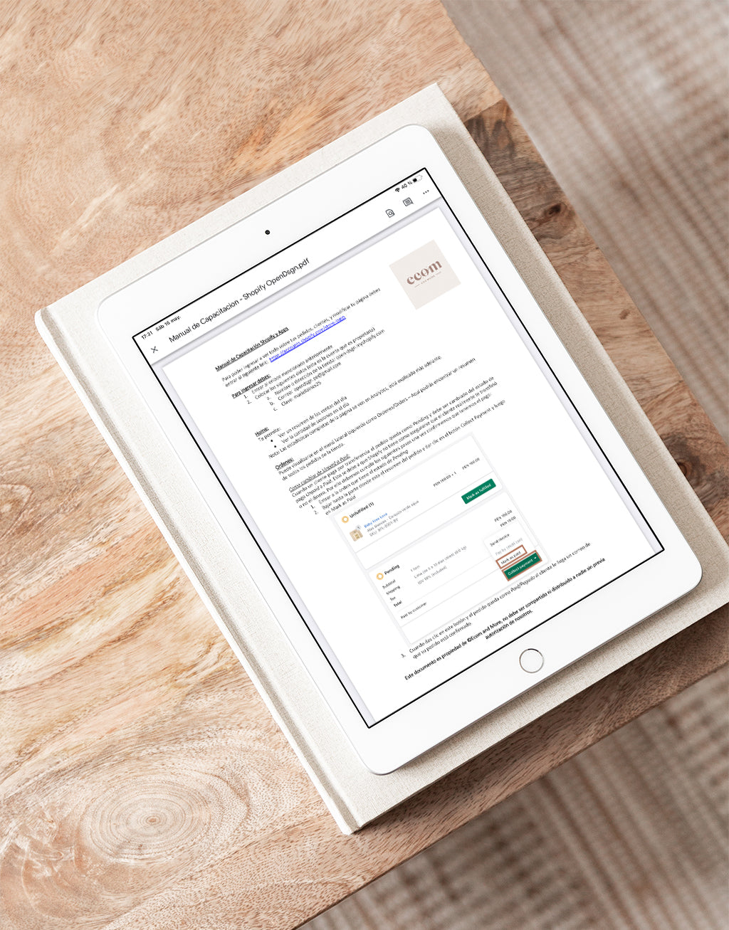 Un Ipad sobre una mesa. En su pantalla se encuentra un documento pdf de un manual de uso de una página web elaborado por Ecom and more para un cliente.