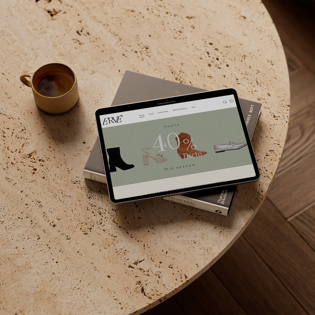 Un Ipad sobre una mesa al lado de una taza de té. En el ipad se encuentra el inicio de la página web de la marca Ervé.