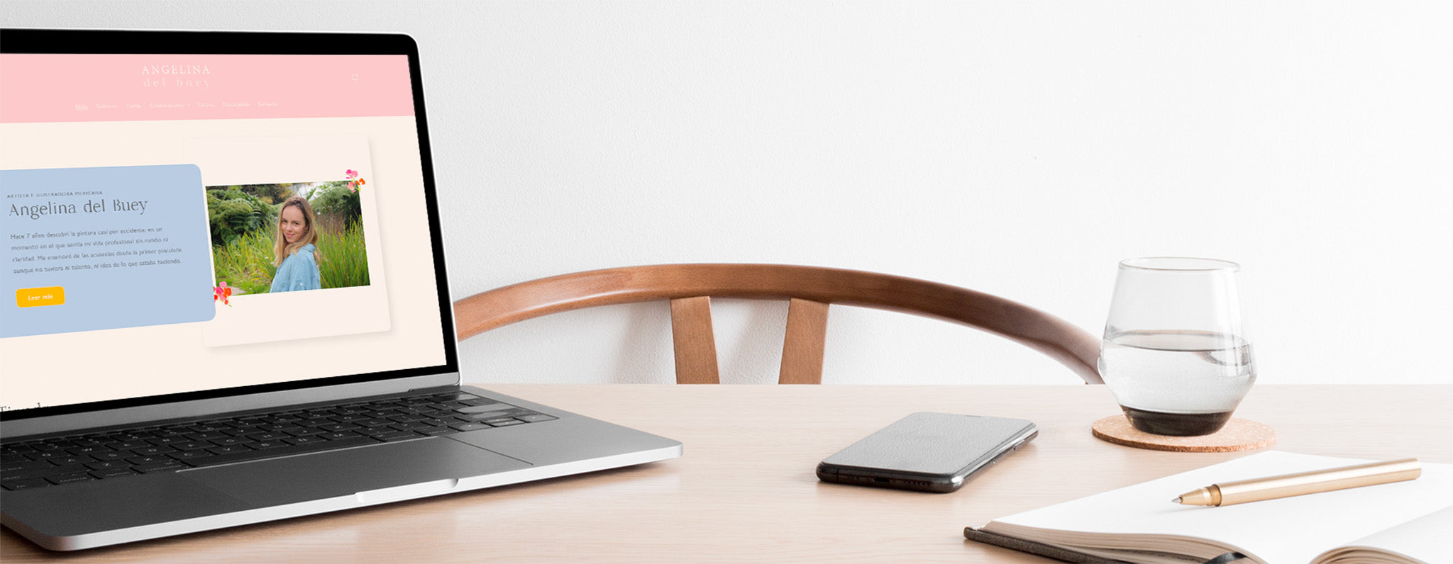 Una laptop abierto sobre una mesa. En su pantalla se encuentra abierto el inicio de la página web de la artista Angelina del Buey.