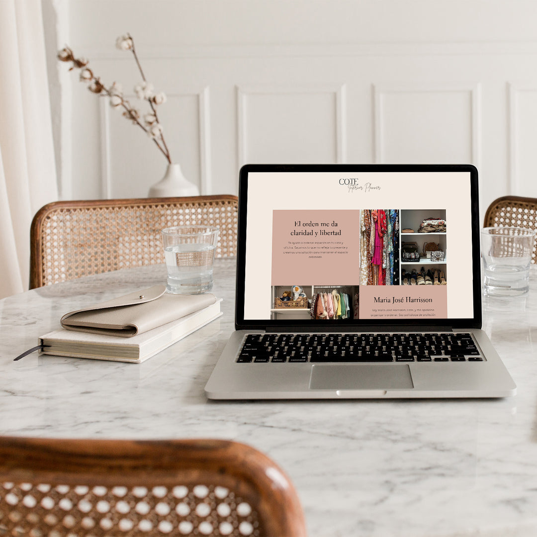 Una laptop sobre una mesa. En la pantalla de la computadora se ve el Inicio de la web del emprendimiento Cote Interior Planner.