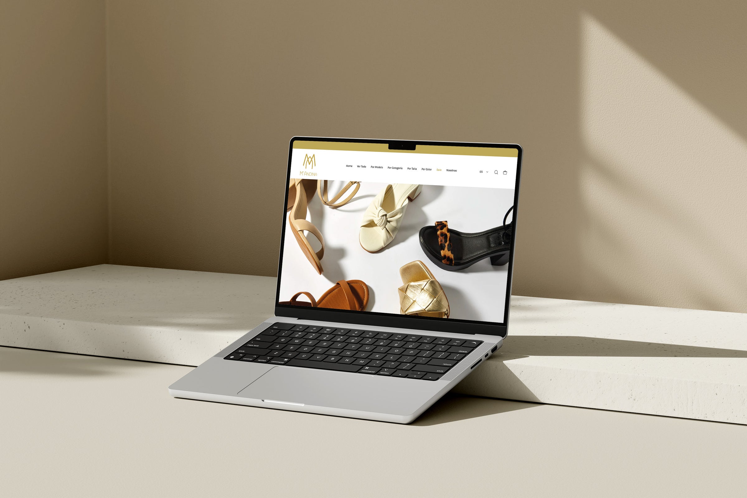 Una laptop sobre una mesa. En la pantalla de la computadora se ve el Inicio de la web de la marca Mandina.