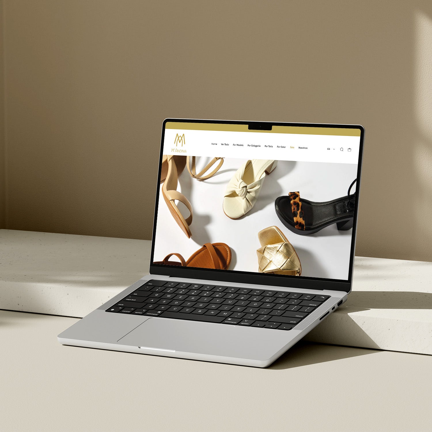 Una laptop sobre una mesa. En la pantalla de la computadora se ve el Inicio de la web de la marca Mandina.