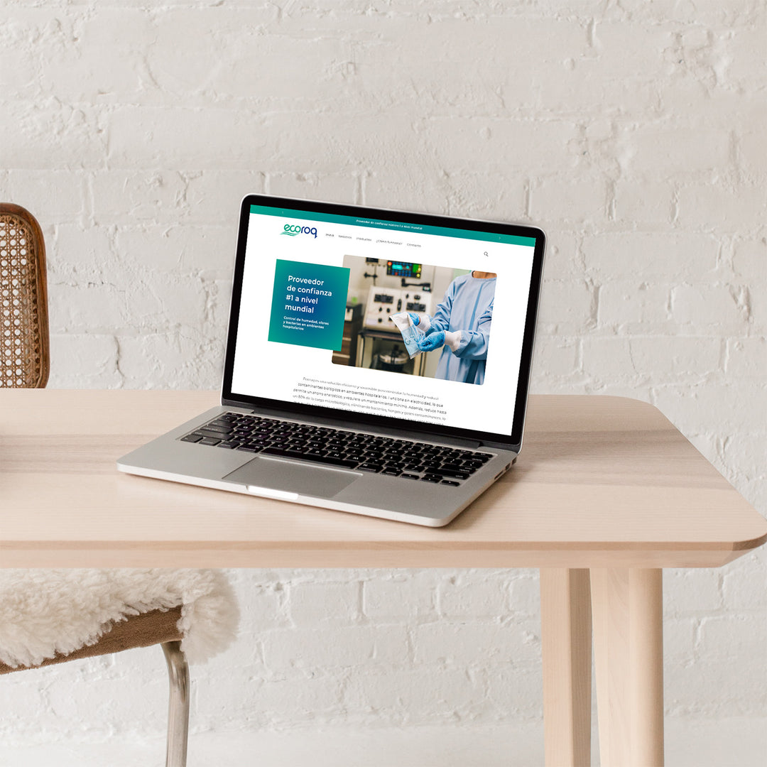 Laptop abierta sobre una mesa. En su pantalla se encuentra abierta el inicio de la página web de la  empresa Ecoroq.