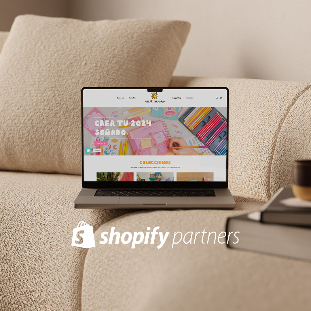 Una laptop abierta sobre un sillón. En la pantalla se muestra la web de Happy Handra. Encima de la imagen está sobreimpreso el logo de Shopify Partners.