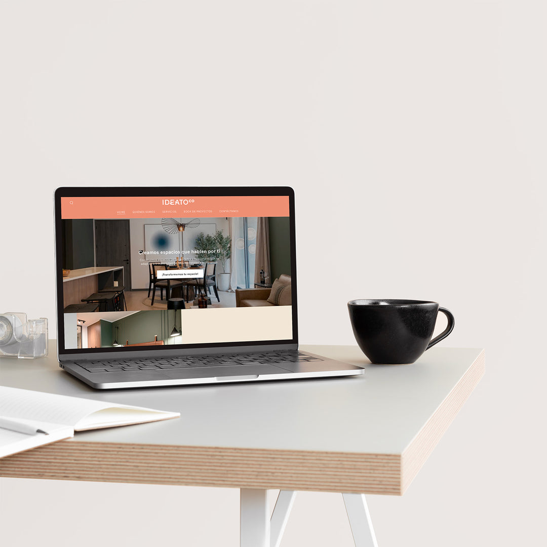 Una laptop sobre una mesa. En la pantalla de la computadora se ve el Inicio de la web de la empresa Ideato Co.