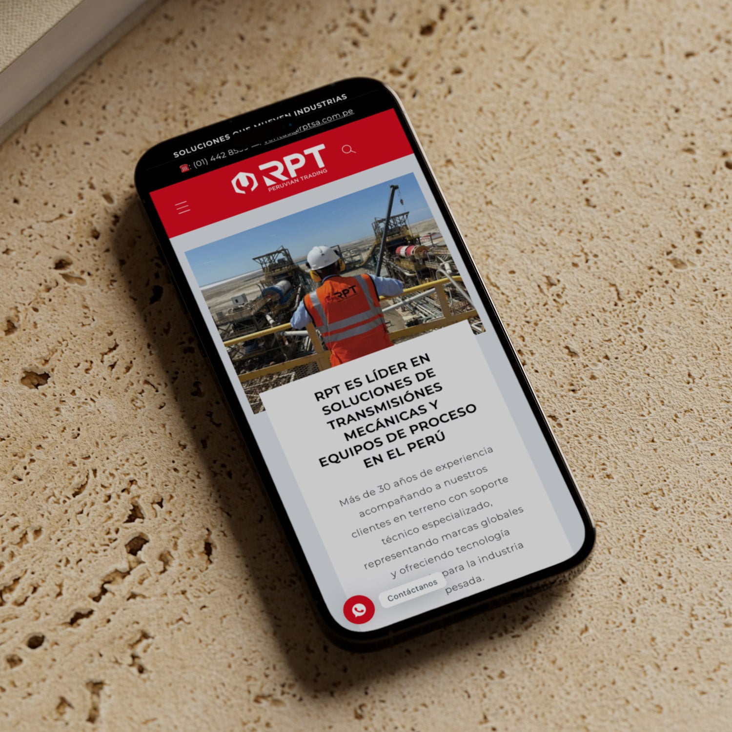 Un iphone sobre una mesa dónde se encuentra abierta en la pantalla la página web de la empresa RPT SA.