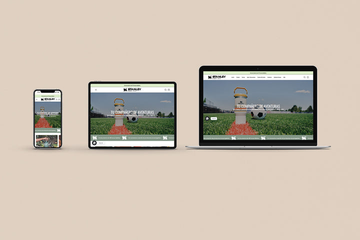 Un Iphone, un Ipad y una laptop mostrando cada uno el inicio de la página web de Stanley. Los tres dispositivos están uno al lado del otro sobre un fondo color entero beige. 