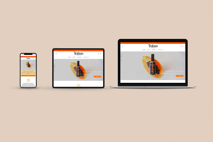 Un Iphone, un Ipad y una laptop mostrando cada uno el inicio de la página web de Trabun Apothecary. Los tres dispositivos están uno al lado del otro sobre un fondo color entero beige. 