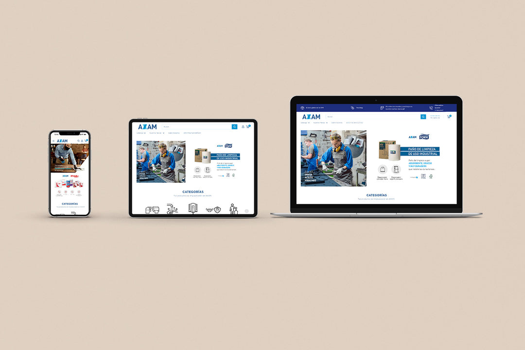 Un Iphone, un Ipad y una laptop mostrando cada uno el inicio de la página web de Axam. Los tres dispositivos están uno al lado del otro sobre un fondo color entero beige. 