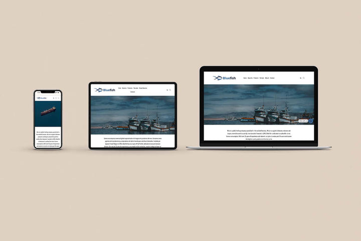 Un Iphone, un Ipad y una laptop mostrando cada uno el inicio de la página web de Blue Fish. Los tres dispositivos están uno al lado del otro sobre un fondo color entero beige. 