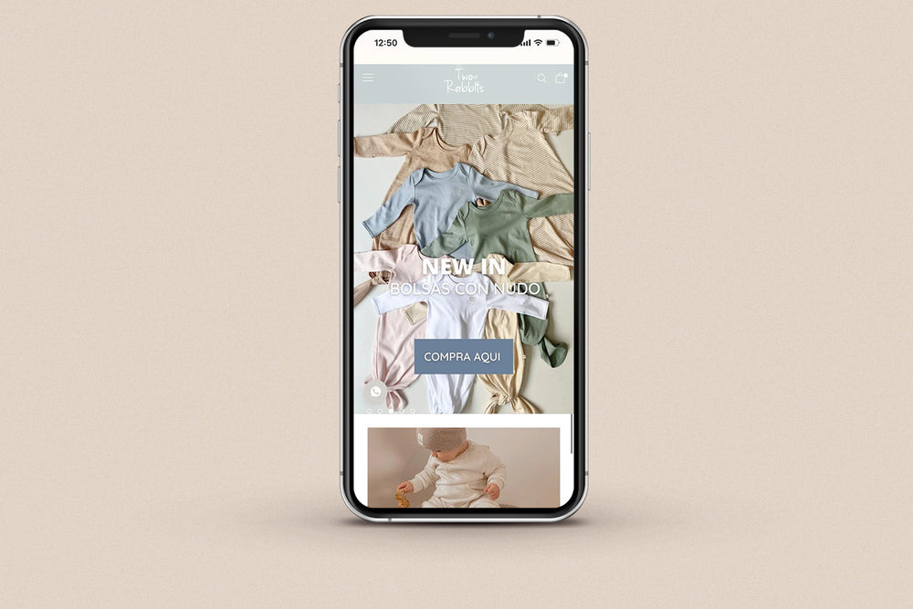 Imagen de un iphone con la web de  Two Rabbits en su pantalla.